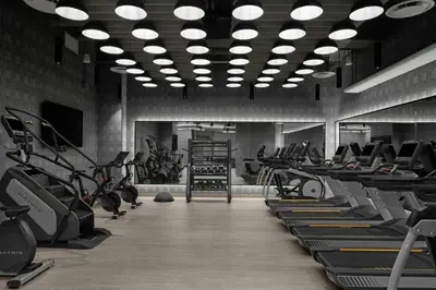 a gym with rows of treadmills and elliptical machines at The Dorian, Autograph Collection in Calgary