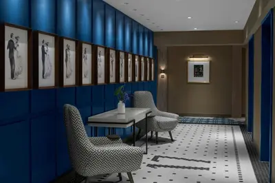 a room with chairs and a table and blue walls at The Dorian, Autograph Collection in Calgary
