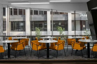 a restaurant with tables and yellow chairs at Courtyard by Marriott Calgary Downtown in Calgary