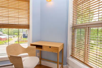 a desk and a chair in a room with windows at Downtown Whitehorse Apartment in Old Town in Whitehorse