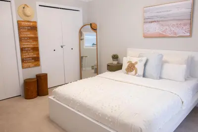a white bedroom with a large white bed with pillows at Harrison On The Lake, Walkable to Beach and Village in Harrison Hot Springs