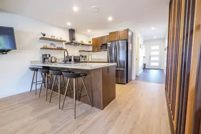 a kitchen with a counter and a refrigerator at Storm Bay, Family Home with Hot Tub and Inlet View in Ucluelet