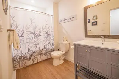 a bathroom with a shower with a toilet and a sink at Storm Bay, Modern 1 Bed Suite and Chefs Kitchen in Ucluelet