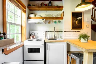 a kitchen with a white stove and a sink at Fern Gully, Coastal Bohemian Loft at Beach in Ucluelet