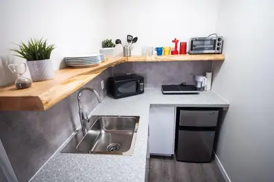 a small kitchen with a sink and a microwave at Kingfisher, Newly Renovated Suite on Ocean Inlet in Ucluelet