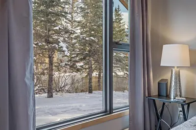 a window with a view of a snow covered yard at Canmore Cabin by Canadian Rockies Vacation Rentals in Canmore