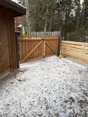 a wooden fence with snow on the ground at Canmore Cabin by Canadian Rockies Vacation Rentals in Canmore