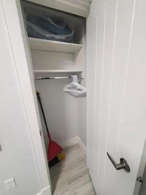 a hallway with a closet with a broom in it at Cozy Guest Suite in Quiet Home with Private Entry in Vancouver