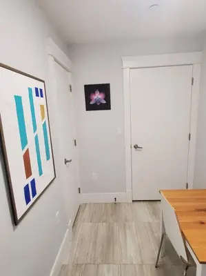 a white room with a door and a painting on the wall at Cozy Guest Suite in Quiet Home with Private Entry in Vancouver