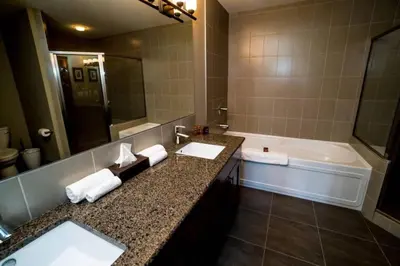 a bathroom with a tub and a sink and a bath tub at Spacious Penthouse Suite-King Beds-Pool & Hot Tub in Canmore