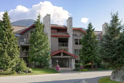 a large building with trees in front of a road at Greyhawk by Whistler Premier in Whistler