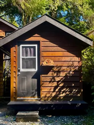 a wooden dog house with a door in it at The Hiker Huts in Port Renfrew