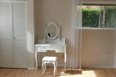 a white dressing table with a mirror and a stool at Happy, Cozy, Loving Guest Space in West Vancouver in West Vancouver