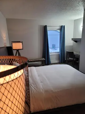 a hotel room with a bed and a window at Parkside Inn in Grande Prairie