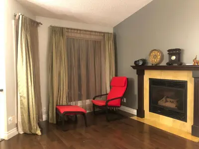a living room with two red chairs and a fireplace at citadel hills valley in Calgary