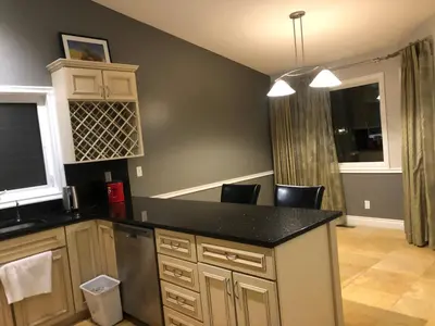 a kitchen with a counter and chairs in a room at citadel hills valley in Calgary