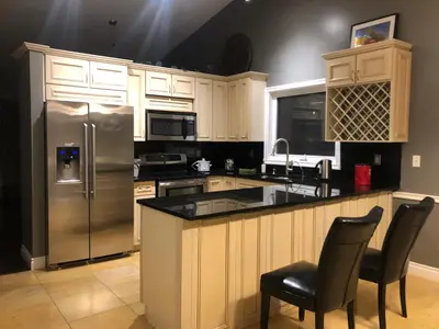 a kitchen with a stainless steel refrigerator and cabinets at citadel hills valley in Calgary
