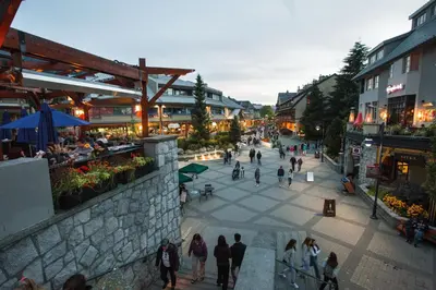 a group of people walking around a street at Whistler Village Centre by Whiski Jack in Whistler