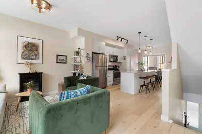 a living room with a green couch and a kitchen at Casa de Luna by Canadian Rockies Vacation Rentals in Canmore