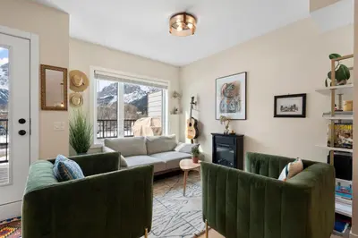 a living room with two green chairs and a couch at Casa de Luna by Canadian Rockies Vacation Rentals in Canmore