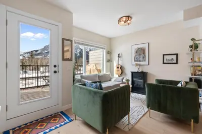 a living room with two green chairs and a couch at Casa de Luna by Canadian Rockies Vacation Rentals in Canmore