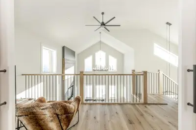 a living room with a ceiling fan and a chair at The White Pearl - Amazing Luxury Chalet with Mountain Views in Big White