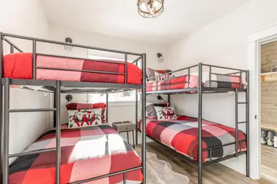 two bunk beds in a boys room with red and black beds at The White Pearl - Amazing Luxury Chalet with Mountain Views in Big White