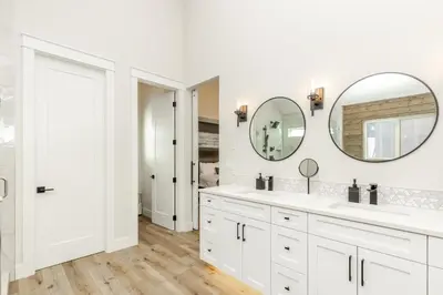 a white bathroom with two sinks and a mirror at The White Pearl - Amazing Luxury Chalet with Mountain Views in Big White