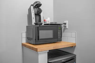 a microwave sitting on top of a wooden shelf at Northwinds Hotel Canmore in Canmore