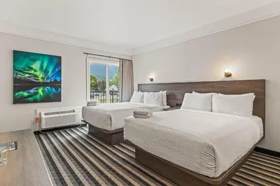 a hotel room with two beds and a window at Northwinds Hotel Canmore in Canmore