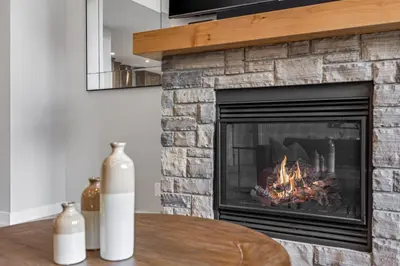 a living room with a fireplace and a table at BRAND NEW - Gorgeous Spring Creek Penthouse in Canmore
