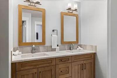 a bathroom with two sinks and two mirrors at BRAND NEW - Gorgeous Spring Creek Penthouse in Canmore