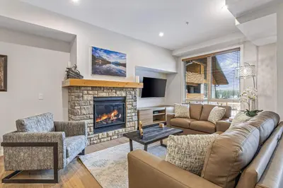 a living room with a couch and a fireplace at Spring Creek Vacations in Canmore
