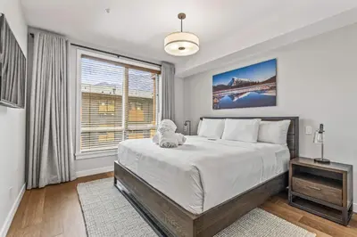 a bedroom with a large bed and a window at Spring Creek Vacations in Canmore