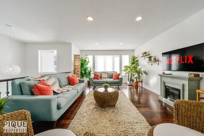 a living room with a couch and a fireplace at Tropical Oasis - King Beds - Free Netflix & Parking - Fast Wi-Fi in Edmonton