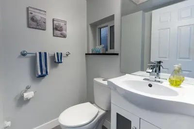 a white bathroom with a toilet and a sink at Suite Sunrise in Vancouver