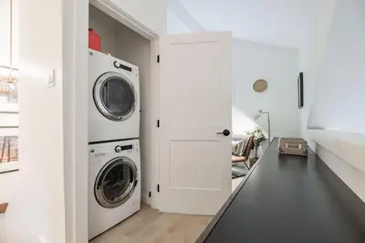 a white laundry room with a washer and dryer at Powderview 24 by Outpost Whistler in Whistler