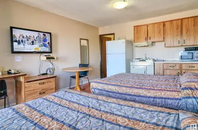 a hotel room with two beds and a kitchen at Kings Court Motel in Cold Lake