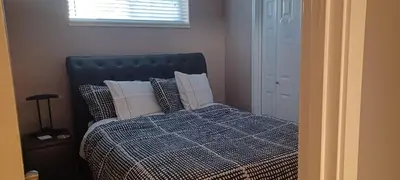 a bedroom with a bed with pillows and a window at Mountain Calm & Private Ensuite Hosted by Maureen in Calgary