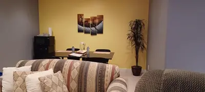 a living room with a couch and a desk at Mountain Calm & Private Ensuite Hosted by Maureen in Calgary