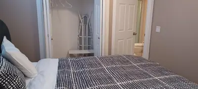 a bedroom with a bed with a black and white comforter at Mountain Calm & Private Ensuite Hosted by Maureen in Calgary