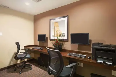 an office with a desk with a computer and chairs at Microtel Inn & Suites by Wyndham Blackfalds in Blackfalds
