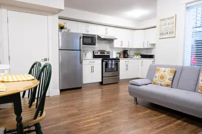 a kitchen and living room with a couch and a table at Modern yet comfy 3 bed suite in Surrey in Surrey