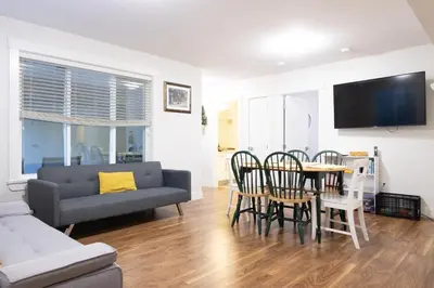 a living room with a couch and a table and chairs at Modern yet comfy 3 bed suite in Surrey in Surrey