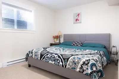 a bedroom with a bed with a quilt and a window at Modern yet comfy 3 bed suite in Surrey in Surrey