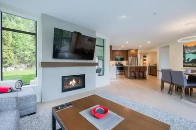 a living room with a fireplace and a table at Ravencrest by Outpost Whistler in Whistler