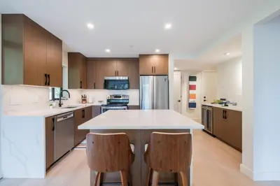 an open kitchen with a white counter top and wooden cabinets at Ravencrest by Outpost Whistler in Whistler