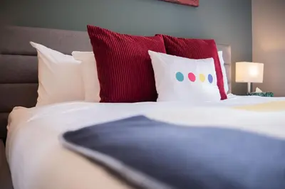 a bed with red and white pillows and red pillows at Ravencrest by Outpost Whistler in Whistler