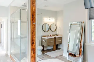 a bathroom with a toilet and a sink and mirrors at Ski in Ski Out with Huge Game Room and Hot Tub in Fernie