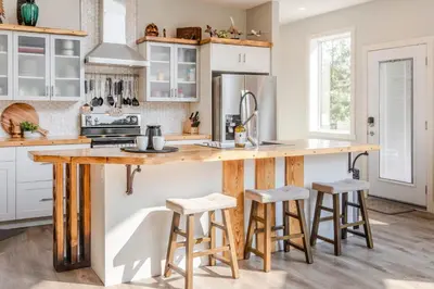a kitchen with a wooden counter and stools at Ski in Ski Out with Huge Game Room and Hot Tub in Fernie